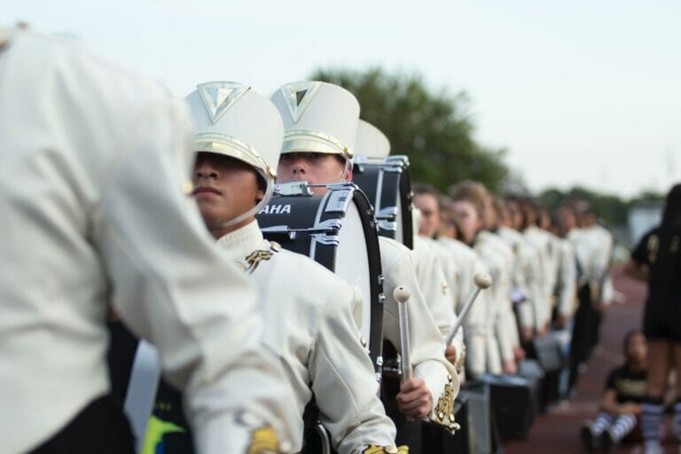 a marching band in white uniforms